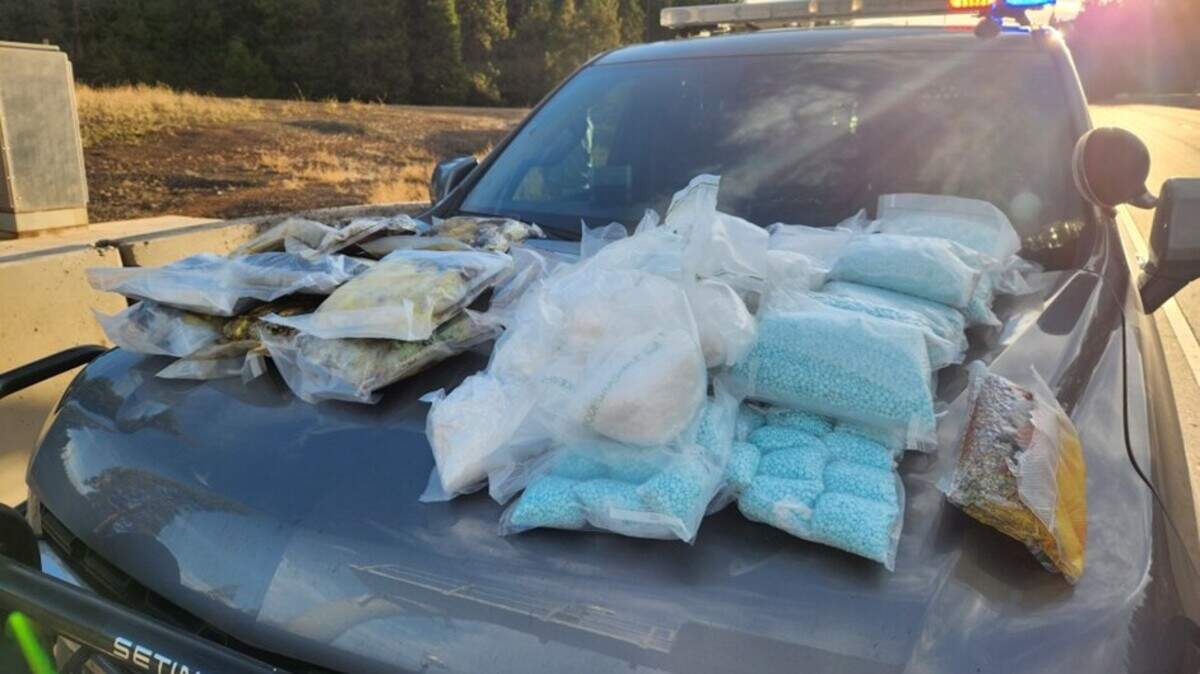 Drugs seized during a federal investigation that snagged a Tacoma man are displayed on the hood of a patrol car.