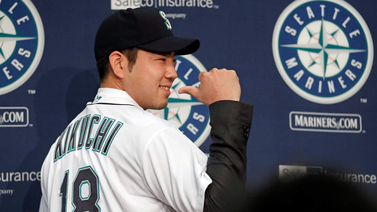 Seattle Mariners pitcher Yusei Kikuchi smiles and shows off his new jersey following a news conference after his signing with the team, Thursday, Jan. 3, 2019, in Seattle. Kikuchi is the latest Japanese star to decide on calling Seattle home in the majors. The Mariners hope their new left-handed pitcher can help in their rebuild process. (AP Photo/Elaine Thompson)