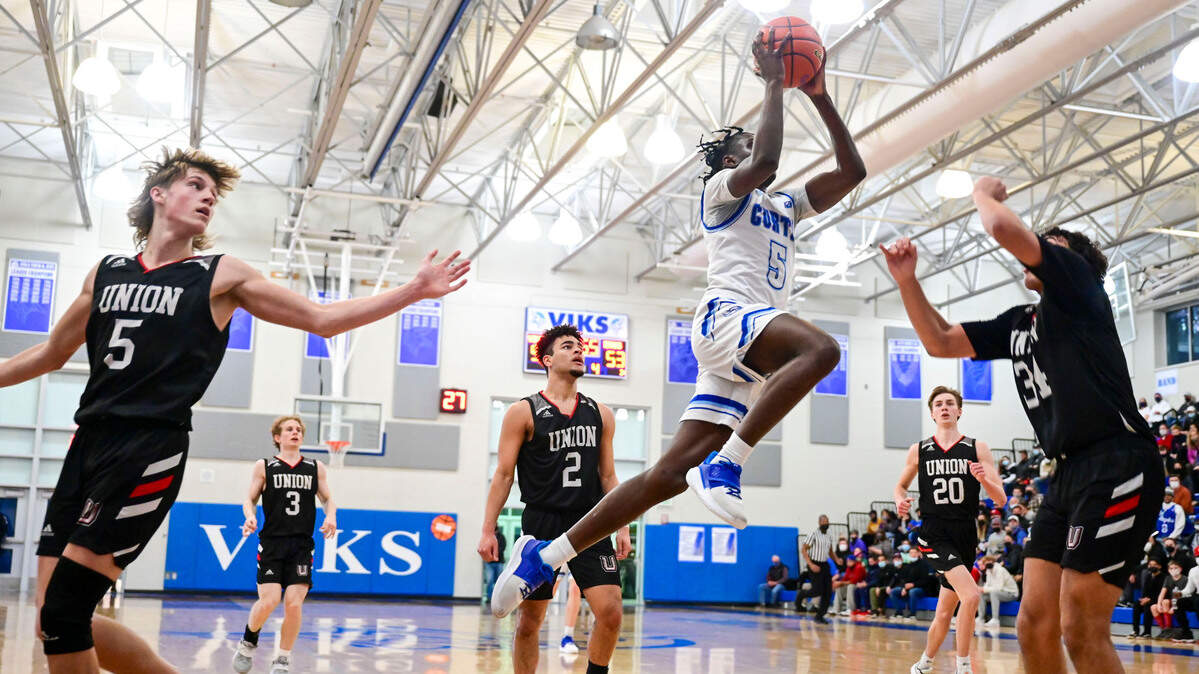 Curtis guard Zoom Diallo (5) drives to the basket in for a layup attempt as Union forward Yanni Fassillis (34) prepares to defend during the fourth quarter of a District 3/4 4A semifinal game on Friday, Feb. 17, 2022, at Curtis High School in University Place, Wash.