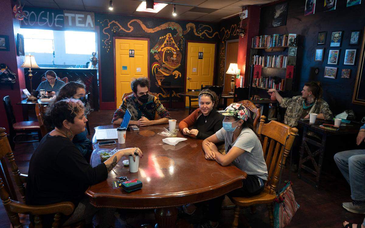 People gather at Burial Grounds Coffee Collective in downtown Olympia, Washington, Friday, Oct. 14, 2022. A celebration and fundraiser on Saturday will thank the community for their support that has kept - and will continue to keep - the coffee shop operating.