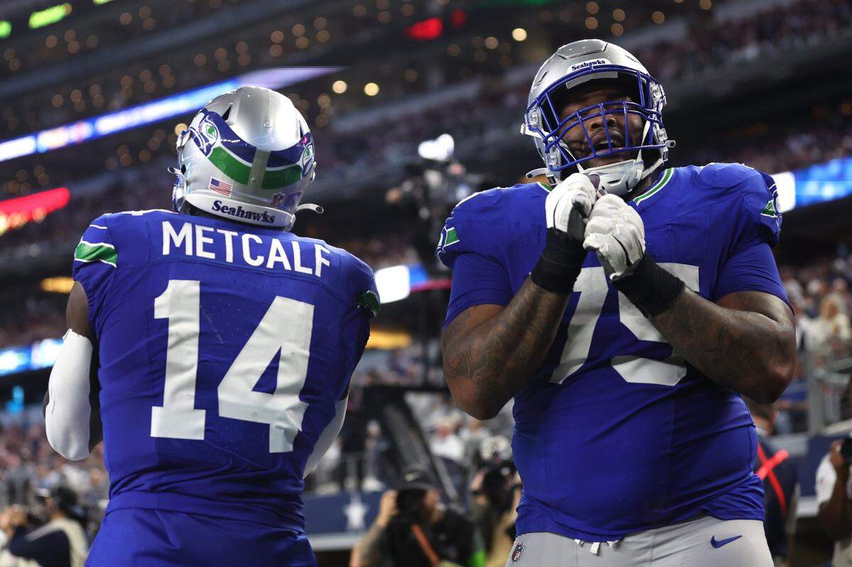 Nov 30, 2023; Arlington, Texas, USA; Seattle Seahawks wide receiver DK Metcalf (14) celebrates with guard Anthony Bradford (75) after scoring a touchdown  against the Seattle Seahawks during the second half at AT&T Stadium. Mandatory Credit: Tim Heitman-USA TODAY Sports