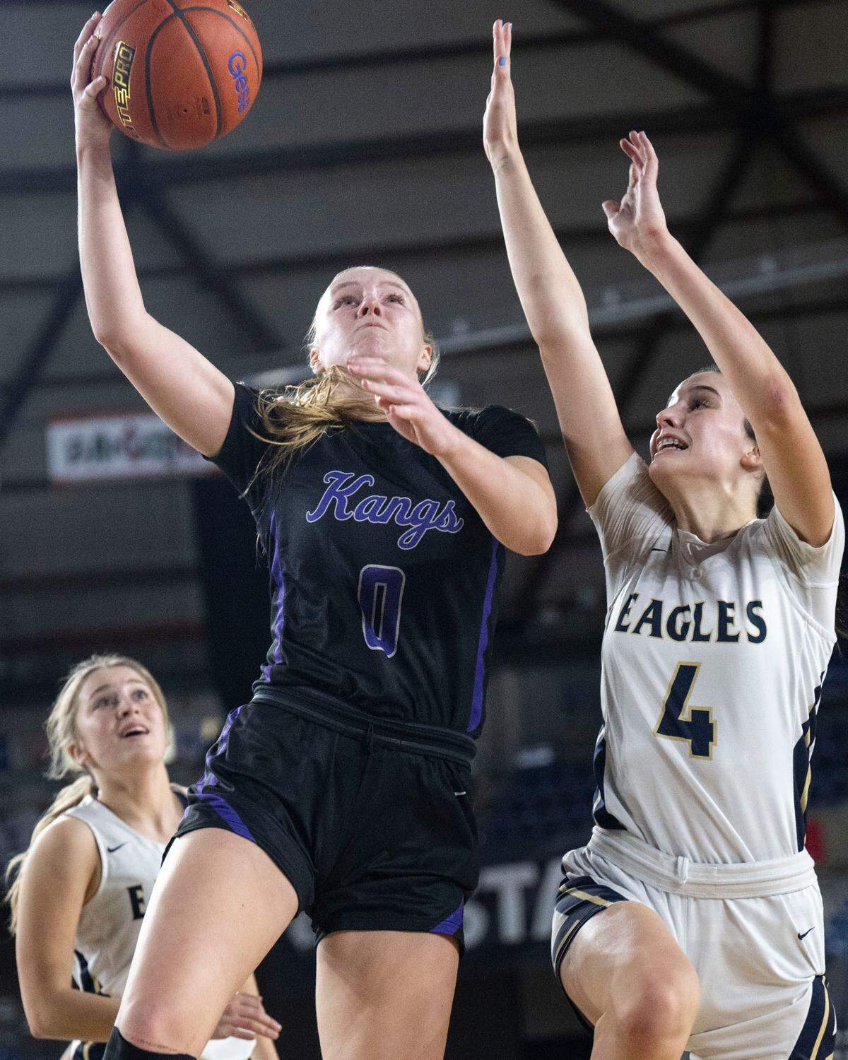 Lake Washington forward Sydney Hani (0) drives to the basket for a layup as Arlington guard Maddy Fischer (4) defends during the second quarter of a Class 3A semifinal game on Friday, March 3, 2023, in Tacoma, Wash.