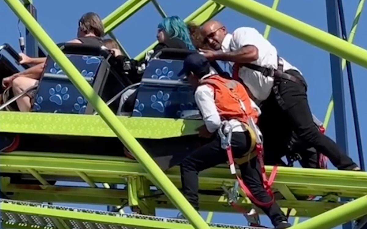 Ride operators push a car with passengers stuck mid-ride on the Wildcat roller coaster at the Washington State Fair in Puyallup, Sept. 1, 2023.