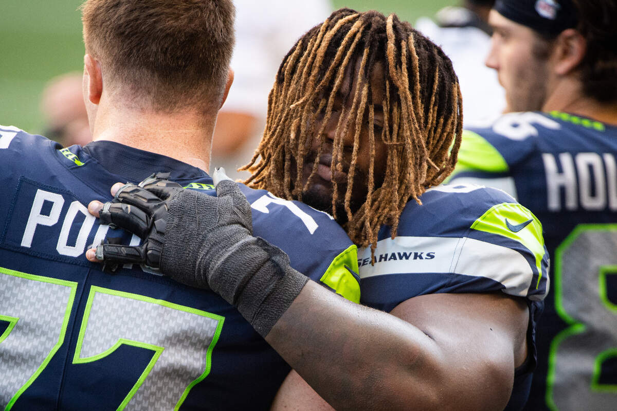 Seattle Seahawks guard Damien Lewis (68) hugs Seattle Seahawks guard Ethan Pocic (77) before the game. The Seattle Seahawks played the New England Patriots in a NFL football game at CenturyLink Field in Seattle, Wash., on Sunday, Sept. 20, 2020.