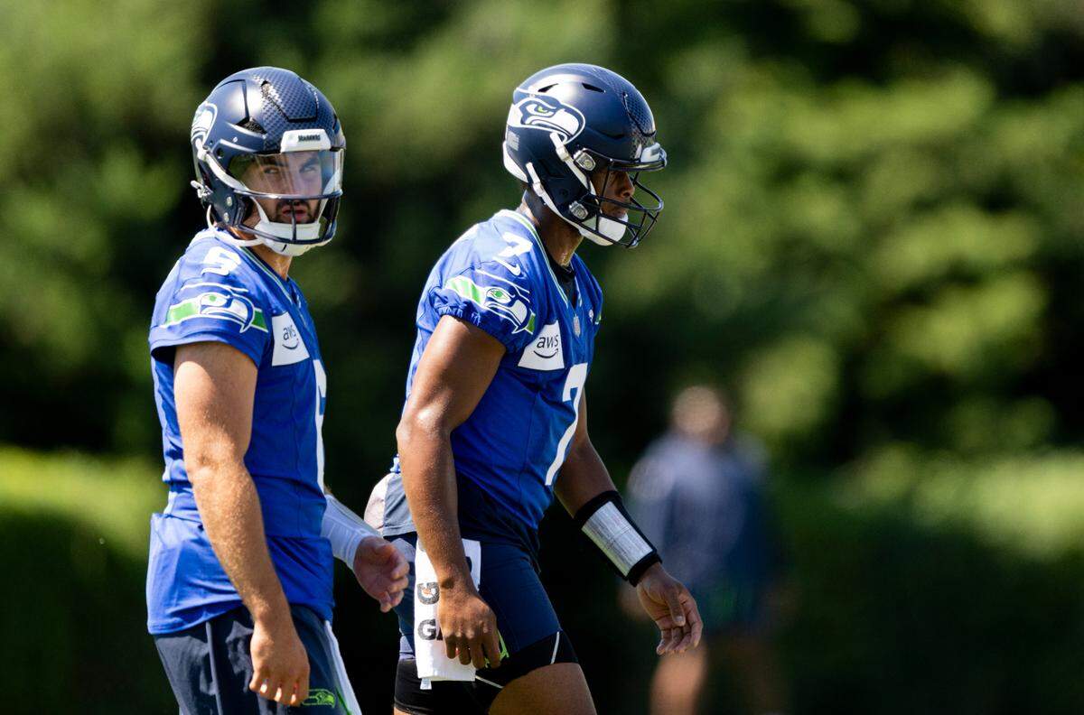 Seattle Seahawks quarterbacks Geno Smith (7) and Sam Howell (6) warm up during the first day of training camp at the Virginia Mason Athletic Center, on Wednesday, July 24, 2024, in Renton.