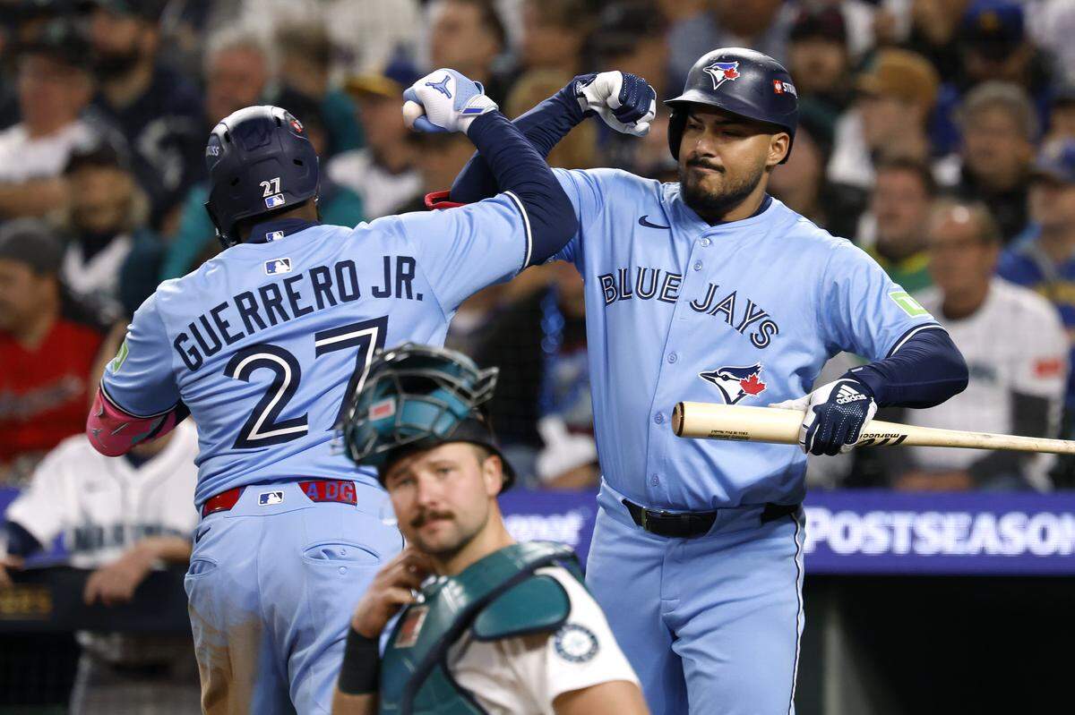 SEATTLE, WASHINGTON - OCTOBER 15: Anthony Santander #25 and Vladimir Guerrero Jr. #27 of the Toronto Blue Jays celebrate after Guerrero Jr. hit a home run during the fifth inning against the Seattle Mariners in game three of the American League Championship Series at T-Mobile Park on October 15, 2025 in Seattle, Washington. (Photo by Alika Jenner/Getty Images)