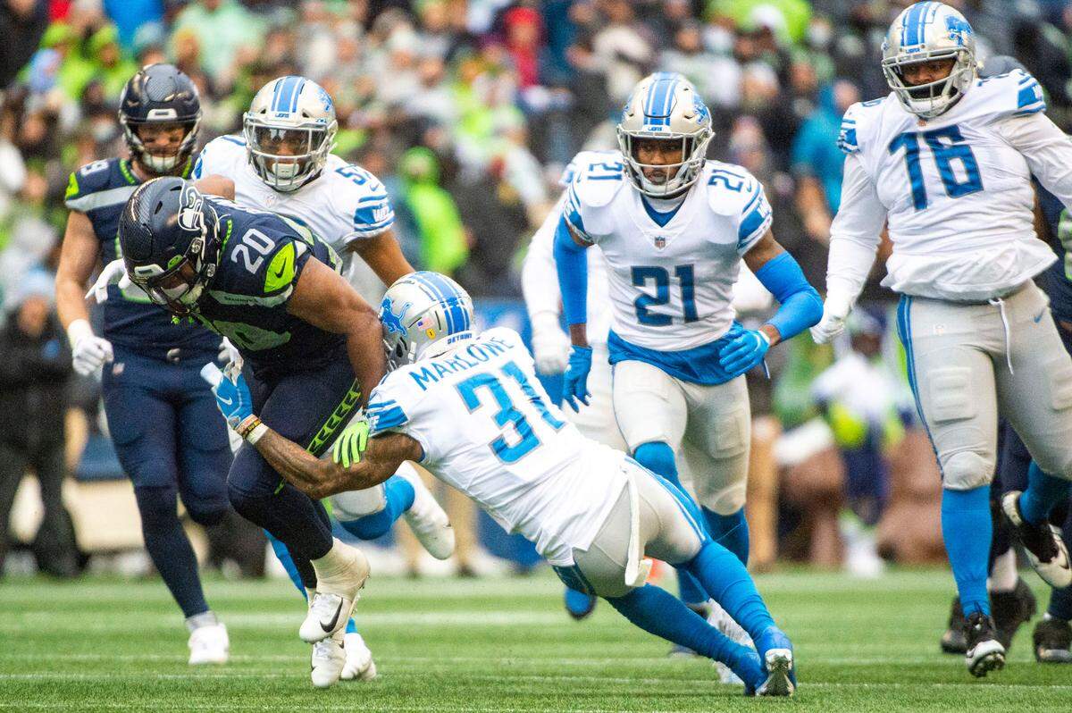 Seattle Seahawks running back Rashaad Penny (20) attempts to break through a tackle by Detroit Lions safety Dean Marlowe (31) during the first quarter of an NFL game on Sunday, Jan. 2, 2022, at Lumen Field in Seattle.