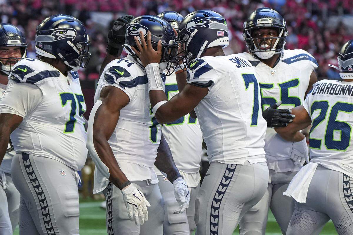 Oct 20, 2024; Atlanta, Georgia, USA; Seattle Seahawks wide receiver DK Metcalf (14) reacts with quarterback Geno Smith (7) after catching a touchdown pass against the Atlanta Falcons during the first half at Mercedes-Benz Stadium. Mandatory Credit: Dale Zanine-Imagn Images
