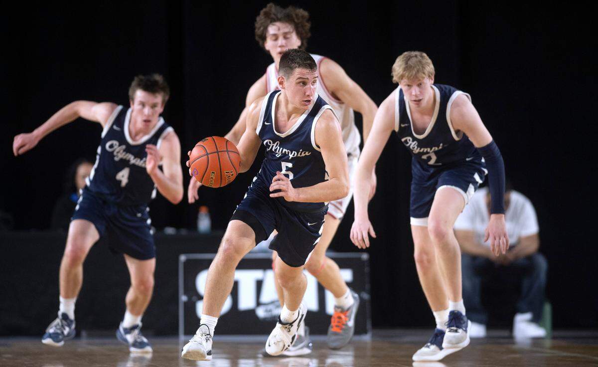 Olympia’s Mason Juergens pushes the ball up court in front of teammates Matt Lindblom (4) and Andreas Engholm during their state semifinal game against the Mount Si Wildcats at the WIAA state basketball tournament in the Tacoma Dome in Tacoma, Washington, on Friday, March 3, 2023.