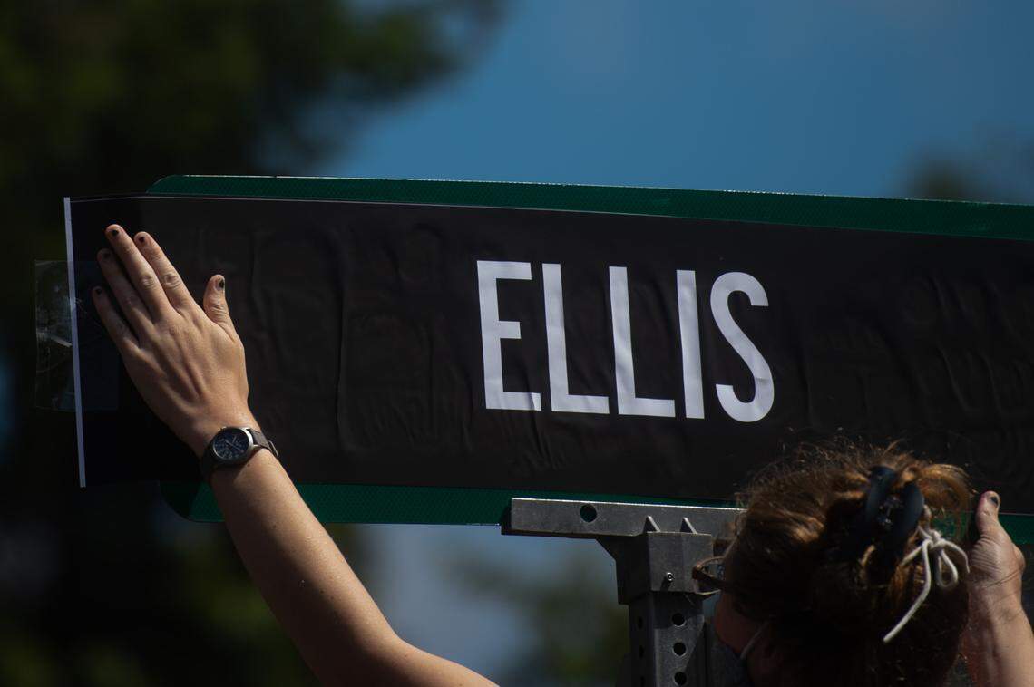 A protester puts up a sign in support of Manuel Ellis in Tacoma, Wash., on Friday, July 10, 2020. Hundreds walked along streets in South Tacoma for Manny Ellis ending at the intersection in which he was killed by police.