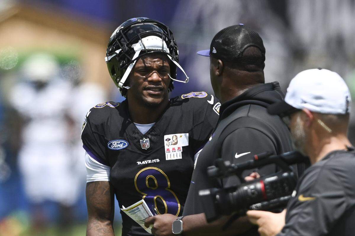 Jul 27, 2024; Owings Mill , MD, USA; Baltimore Ravens quarterback Lamar Jackson  speaks with quarback coach Tee Martin during the afternoon session of training camp at the Under Armour Performance Center,  Mandatory Credit: Tommy Gilligan-USA TODAY Sports
