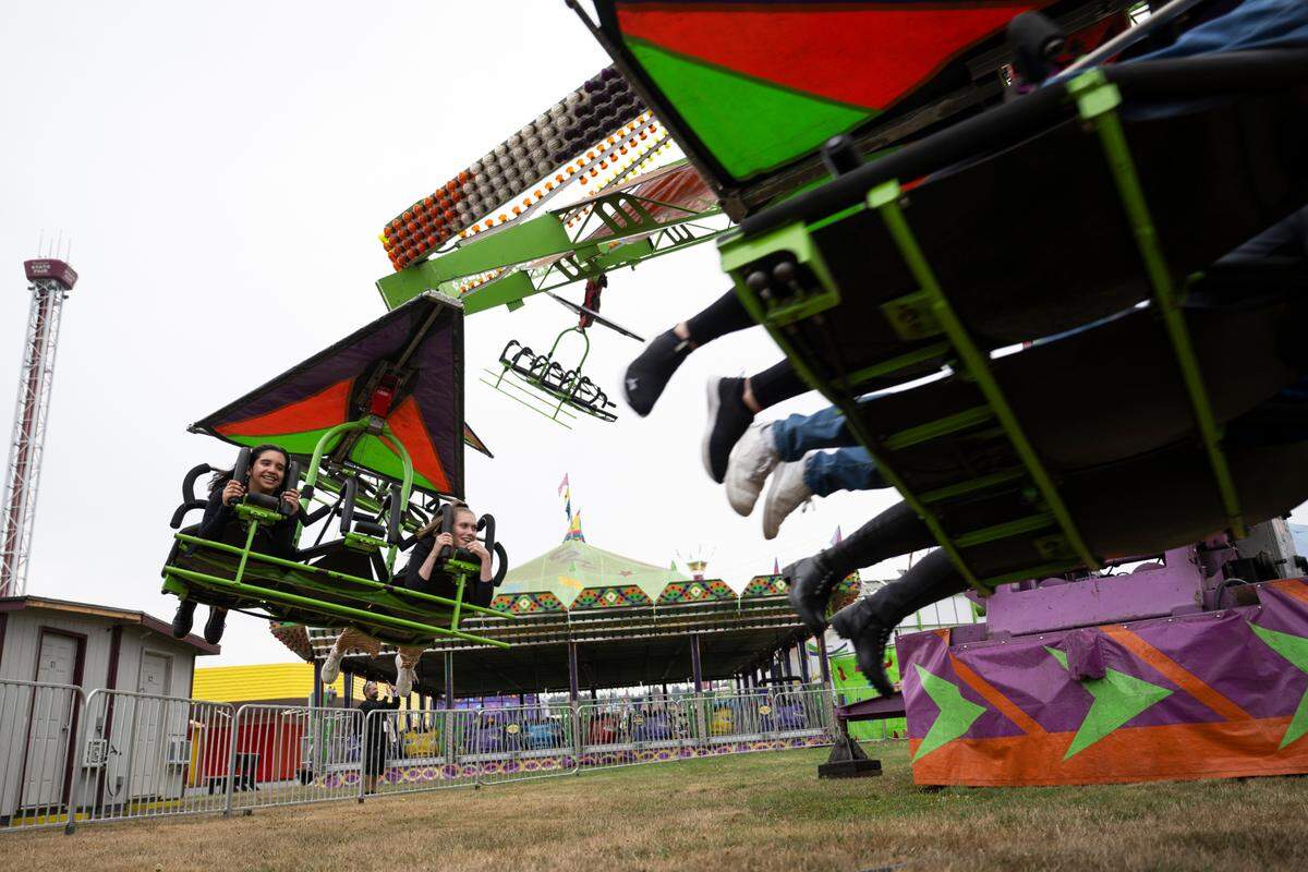 Members of the media ride the cliff hanger at the Washington State Fair, Thursday, Aug. 31, 2023, Puyallup, Wash.