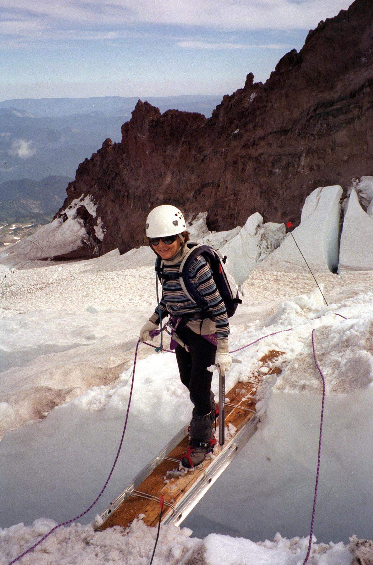Bronka Sundstrom, then 77, crosses over a crevasse at 11,350 feet up Mount Rainier on Aug. 31, 2002. Sundstrom set a record for the oldest woman to climb Rainier and one of few climbers of any age to go up and down the same day.