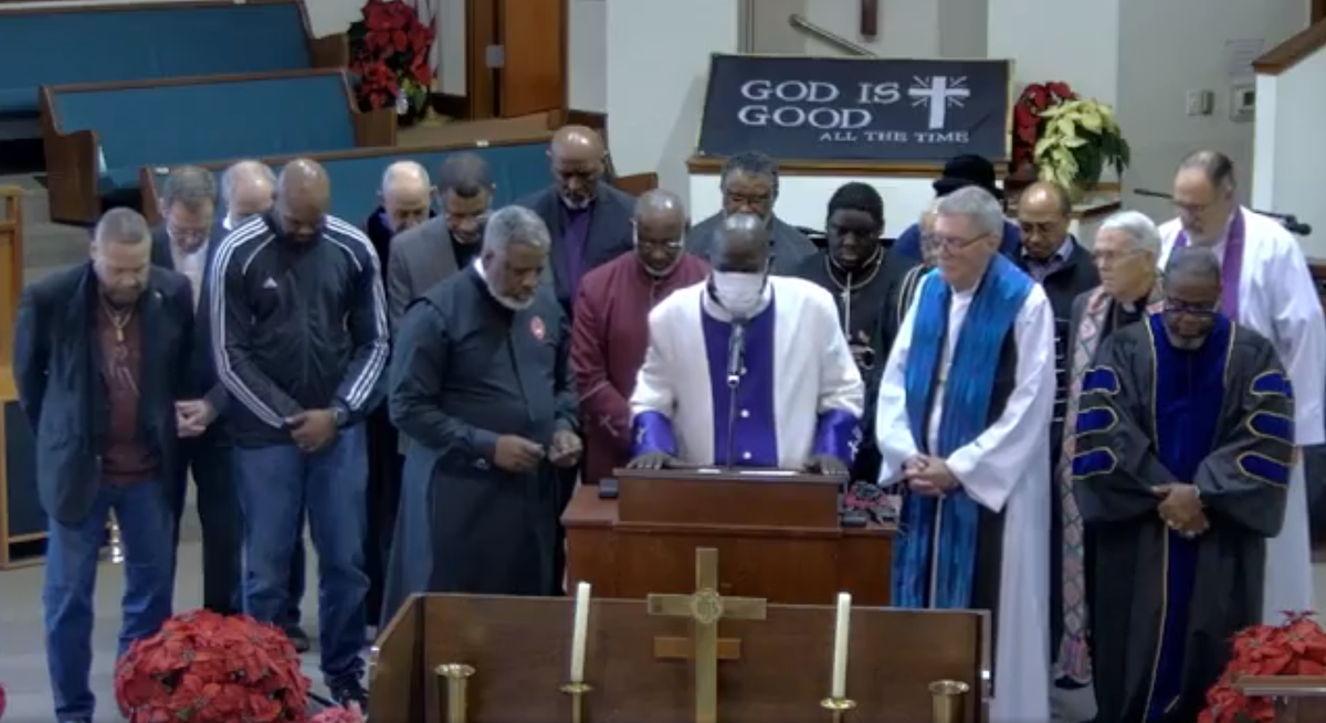 Bishop Lawrence White (left of center), president of the Tacoma Ministerial Alliance, prays with other Tacoma faith leaders Friday, Dec. 22, 2023, at Shiloh Baptist Church. The leaders gathered to pray for the families of both Manuel Ellis and the officers tried for his death in their custody.