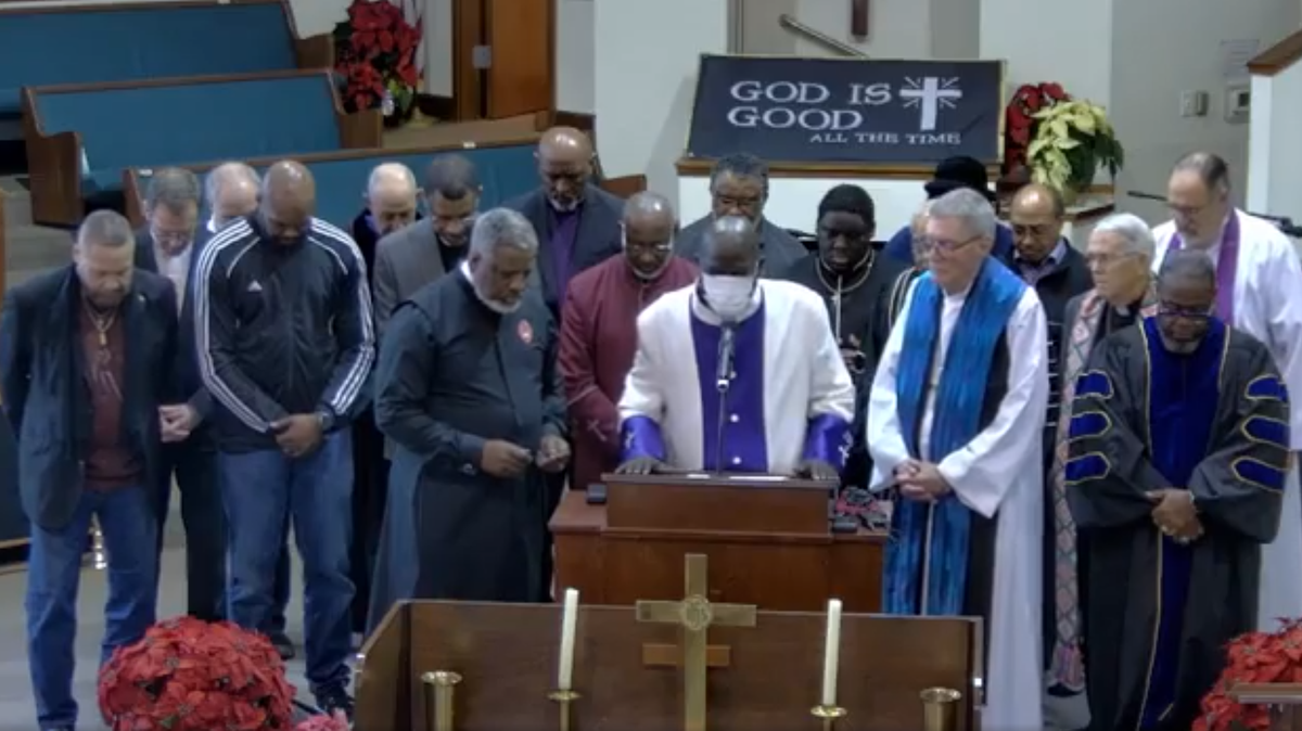 Bishop Lawrence White (left of center), president of the Tacoma Ministerial Alliance, prays with other Tacoma faith leaders Friday, Dec. 22, 2023, at Shiloh Baptist Church. The leaders gathered to pray for the families of both Manuel Ellis and the officers tried for his death in their custody.
