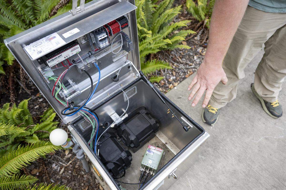 Doug Gibbons, a field technician and seismology lab coordinator for the Pacific Northwest Seismic Network, points out all of the tools found at an urban station, which fit into a 20-inch-by-20-inch silver box located in Tehaleh Heights Elementary’s courtyard on Thursday, Sept. 11, 2025, in Bonney Lake.