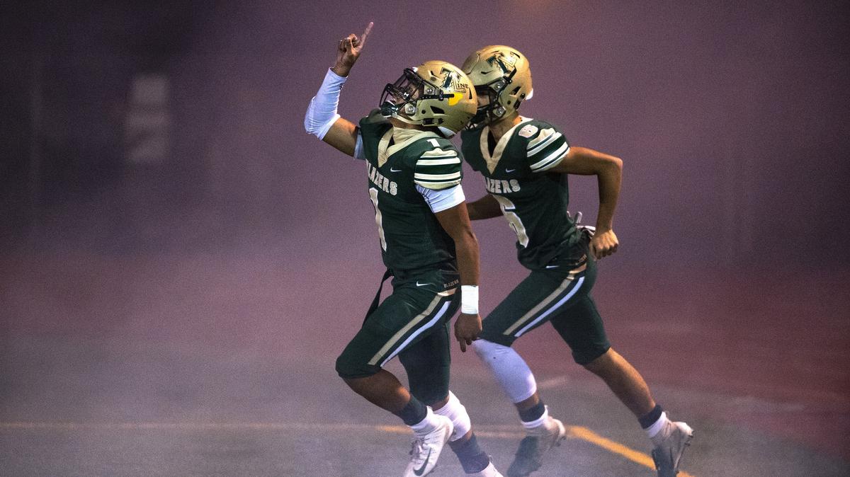 Timberline seniors Nephi Vimoto (1) and Isaiah Jerenz enter the field before during Friday night’s football game against Oak Harbor at South Sound Stadium in Lacey on Nov. 2, 2018.