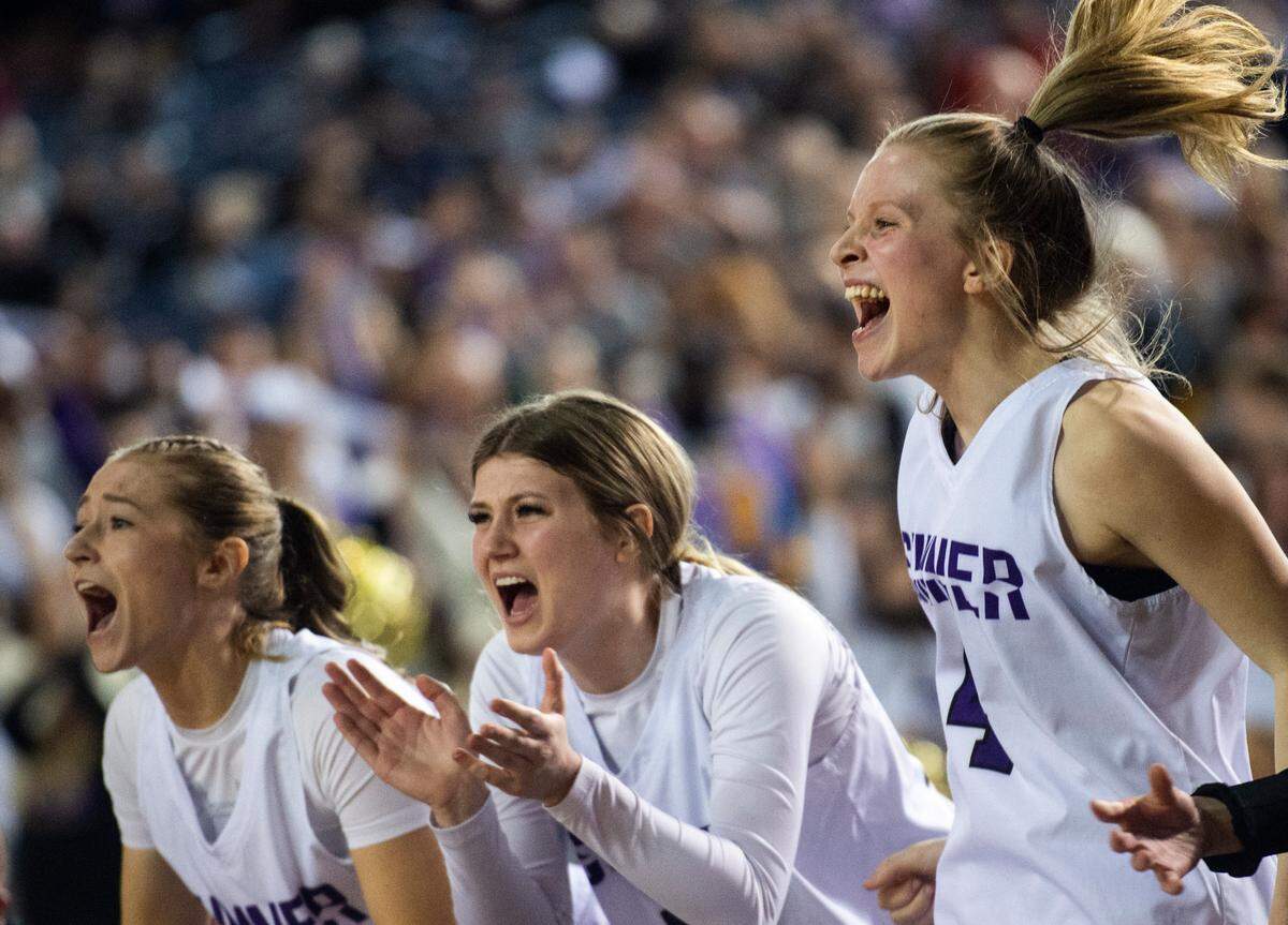 Sumner’s guard Anuhea Borden (4), forward Camryn Hermsmeyer (14) and guard Ella Olson (13) cheer on their teammates from the bench during the Class 4A quarterfinal state tournament game on Thursday, March 3, 2022, at the Tacoma Dome, in Tacoma, Wash.