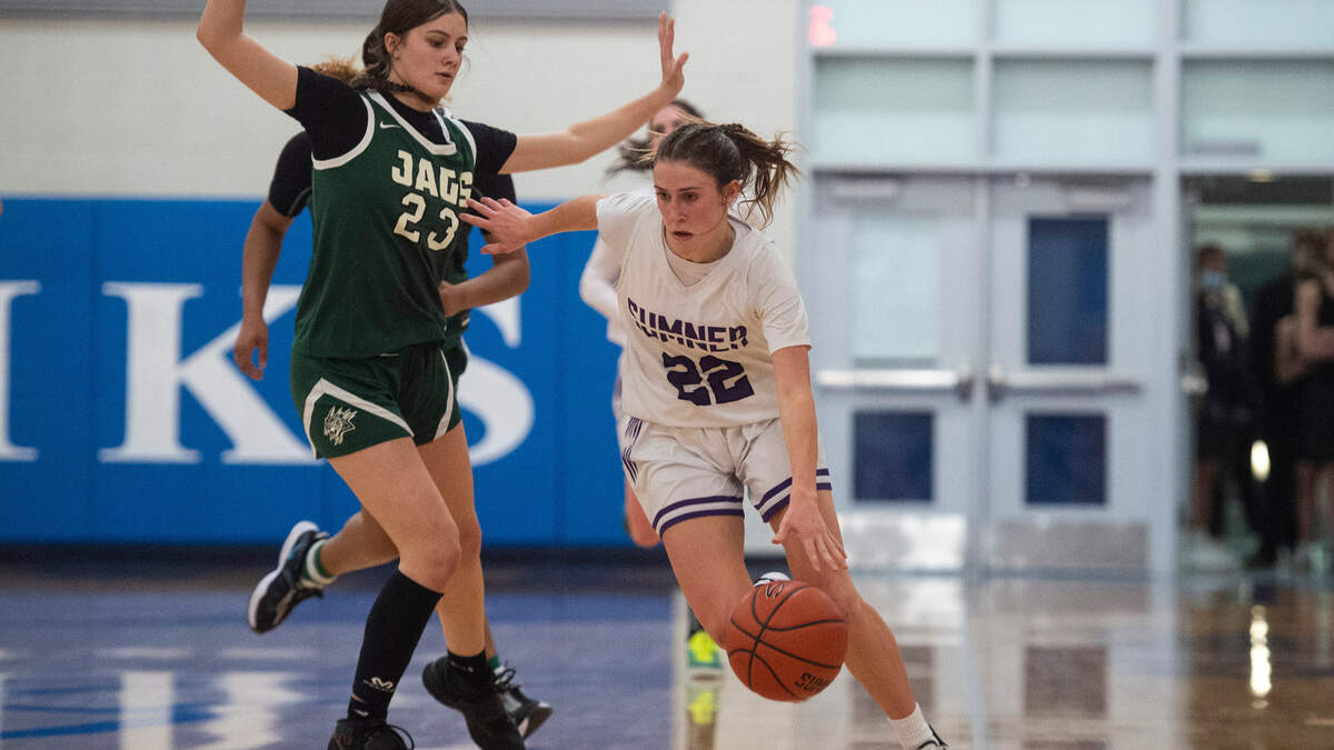 Sumner’s guard Lainee Houillon (22) dribbles around Emerald Ridge’s guard Alina Sapilak (23) during the 4A District 3/4 high school girls basketball championship game at the Curtis High School on Saturday, Feb. 19, 2022, in University Place, Wash.