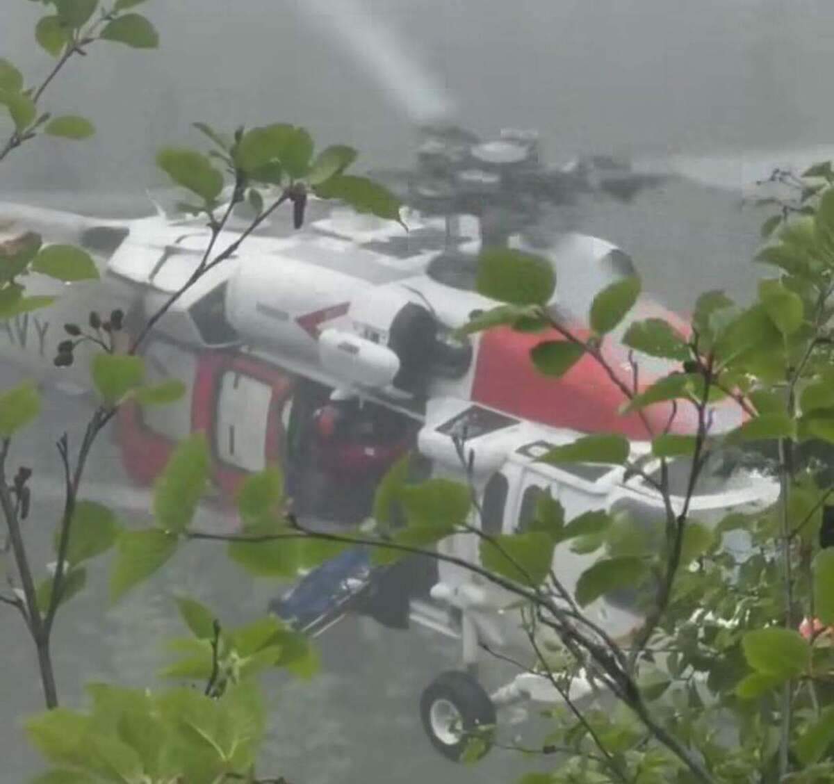 A Navy helicopter from Station SAR Whidbey knighthawk hovers as a fall victim is hoisted into its cabin Friday morning.