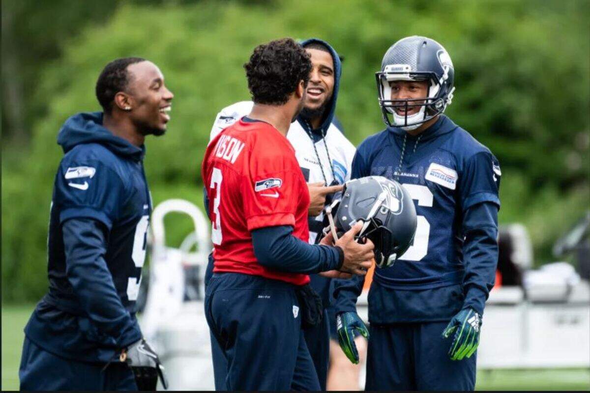 All-Pro middle linebacker Bobby Wagner (in white jersey) jokes with quarterback Russell Wilson (red) and teammates on the Seahawks’ first day of organized team activities for this offseason, Monday at team headquarters in Renton.