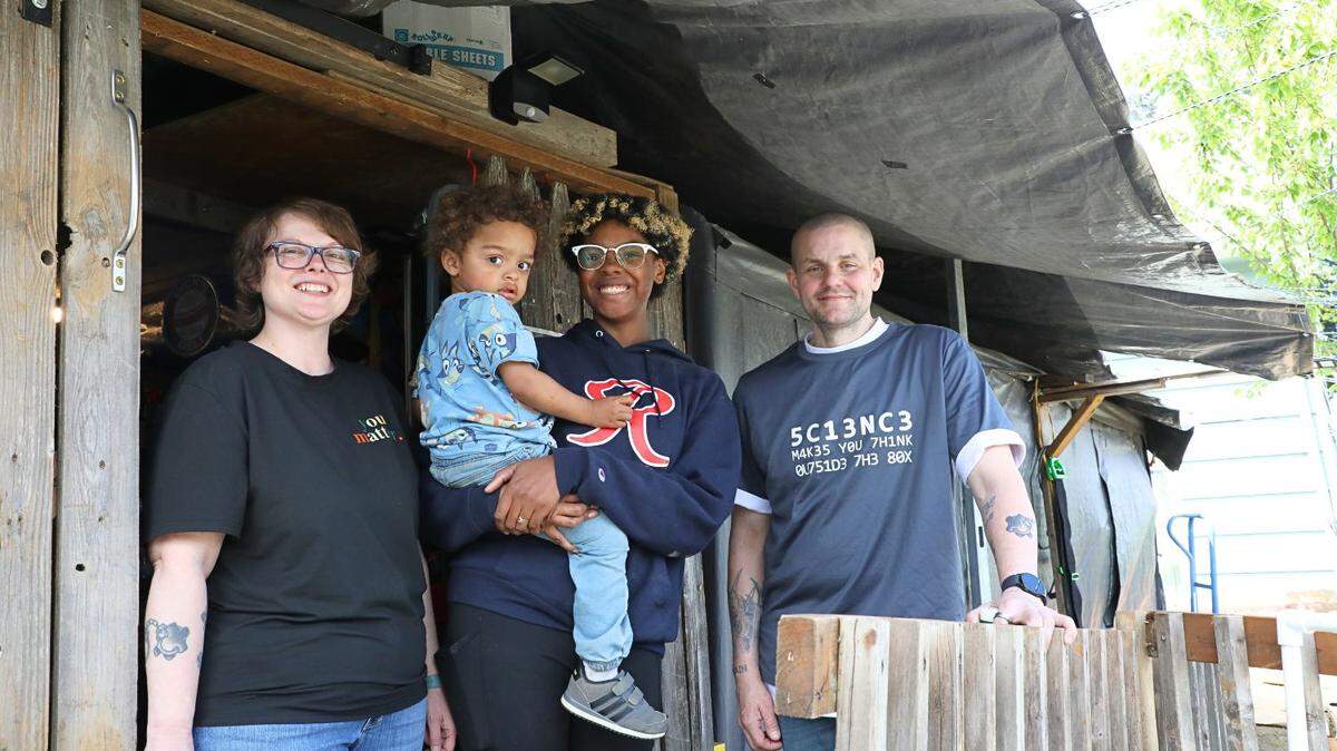 The board members of Lifting Spirits with Helping Hands, Shatone Martin, Desiree Hubbert, and Kenny Weller, in front of their makeshift medical equipment warehouse.