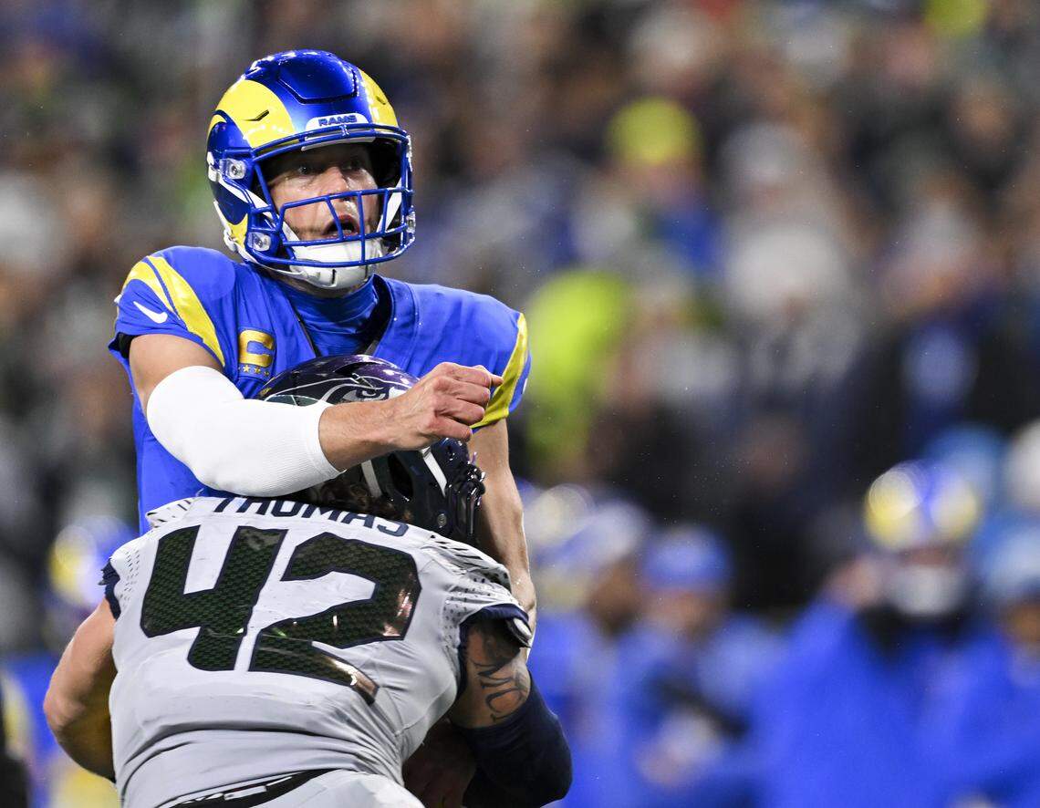 Seattle Seahawks linebacker Drake Thomas (42) hits Los Angeles Rams quarterback Matthew Stafford (9) as he throws during the first quarter of the game at Lumen Field, on Thursday, Dec. 18, 2025, in Seattle.