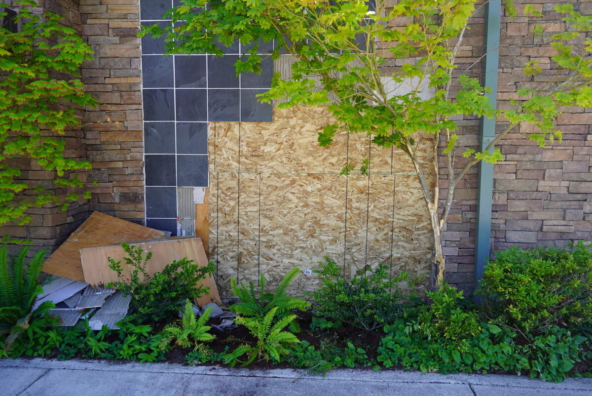 Boards covers the hole where a car crashed into Bloom Boutique on Saturday, June 20, 2026, in Gig Harbor, Wash.