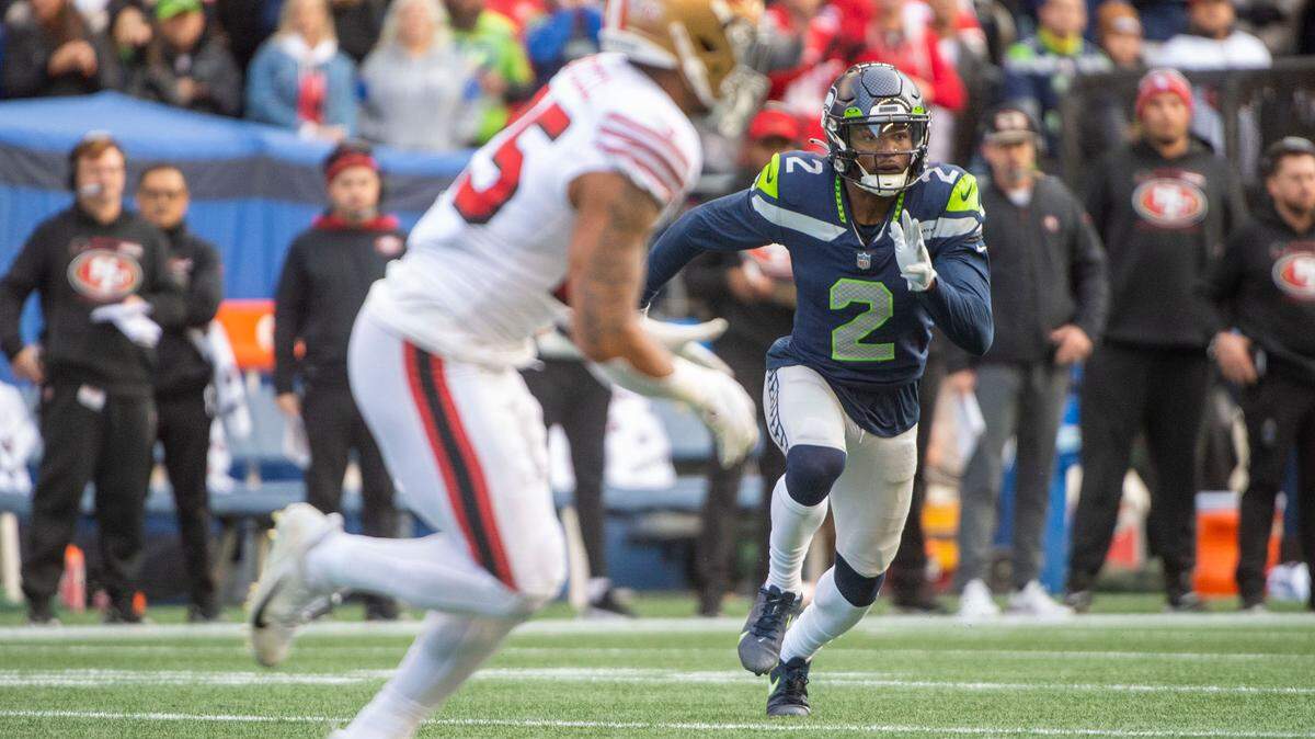 Seattle Seahawks cornerback D.J. Reed (2) rushes San Francisco 49ers quarterback Jimmy Garoppolo as running back Eli Mitchell (25) prepares to take a handoff during the first quarter of an NFL game on Sunday at Lumen Field in Seattle.