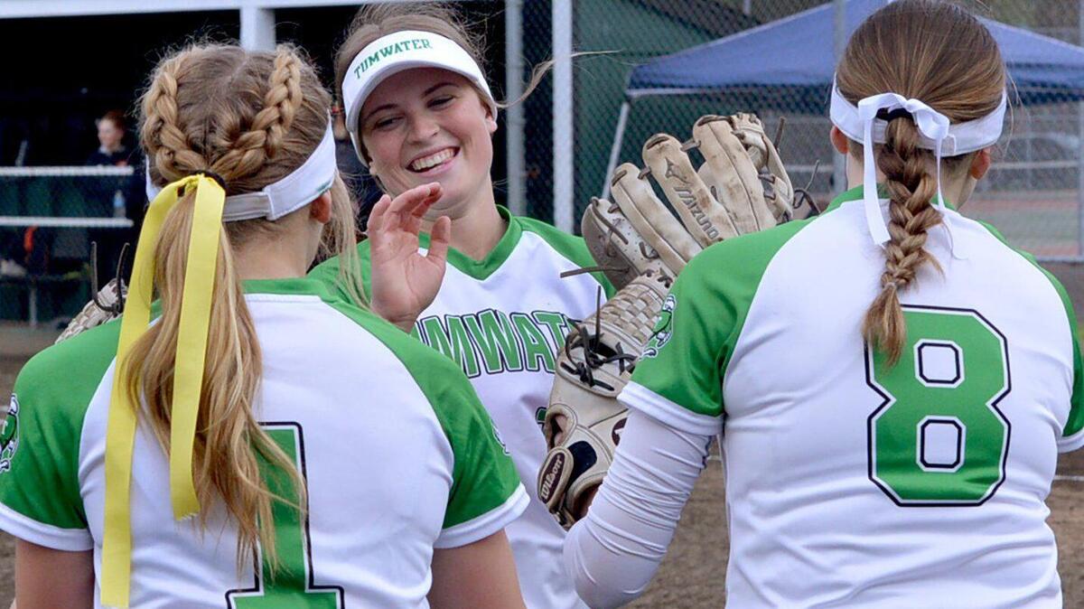 Tumwater’s Aly Waltermeyer gets welcomed by teammates Ella Ferguson (L) and Scout Abbott during player introductions during the T-Birds’ April 27 home game against Centralia.
