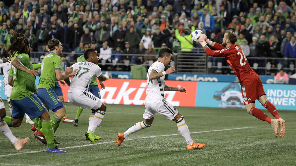 Seattle Sounders goalkeeper Stefan Frei, right, pushes out a ball as Portland Timbers defender Liam Ridgewell, second from left, closes in, during the first half of the second leg of an MLS soccer playoff series Thursday, Nov. 8, 2018, in Seattle. (AP Photo/Ted S. Warren)