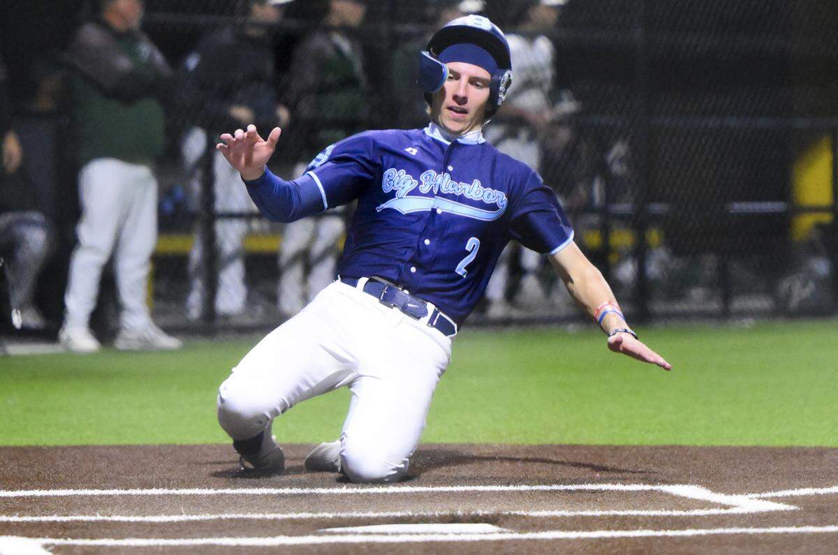 Gig Harbor's Daniel Sleeter (2) slides in to home plate against Peninsula during the 3A Puget Sound League baseball league championship game at Lincoln High School, on Wednesday, May 6, 2026, in Tacoma, Wash.