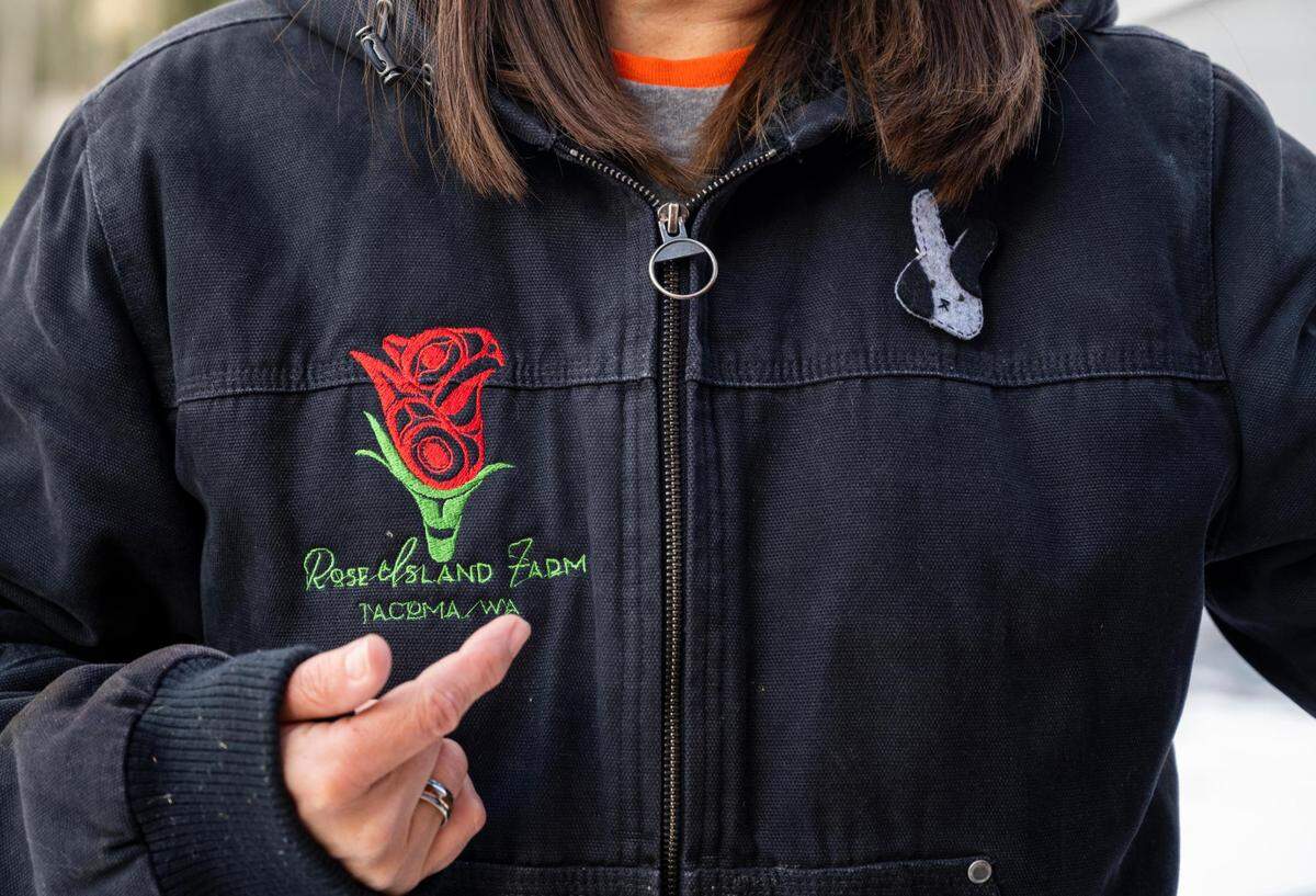 Melissa Meyer, Rose Island Farm owner, wears a jacket with the farm’s name sewn on it at the farm on Thursday, Feb. 24, 2022, in Tacoma, Wash. Rose Island Farm is an Indigenous-owned family farm that provides skill share workshops, food and herbal supports for the BIPOC community.