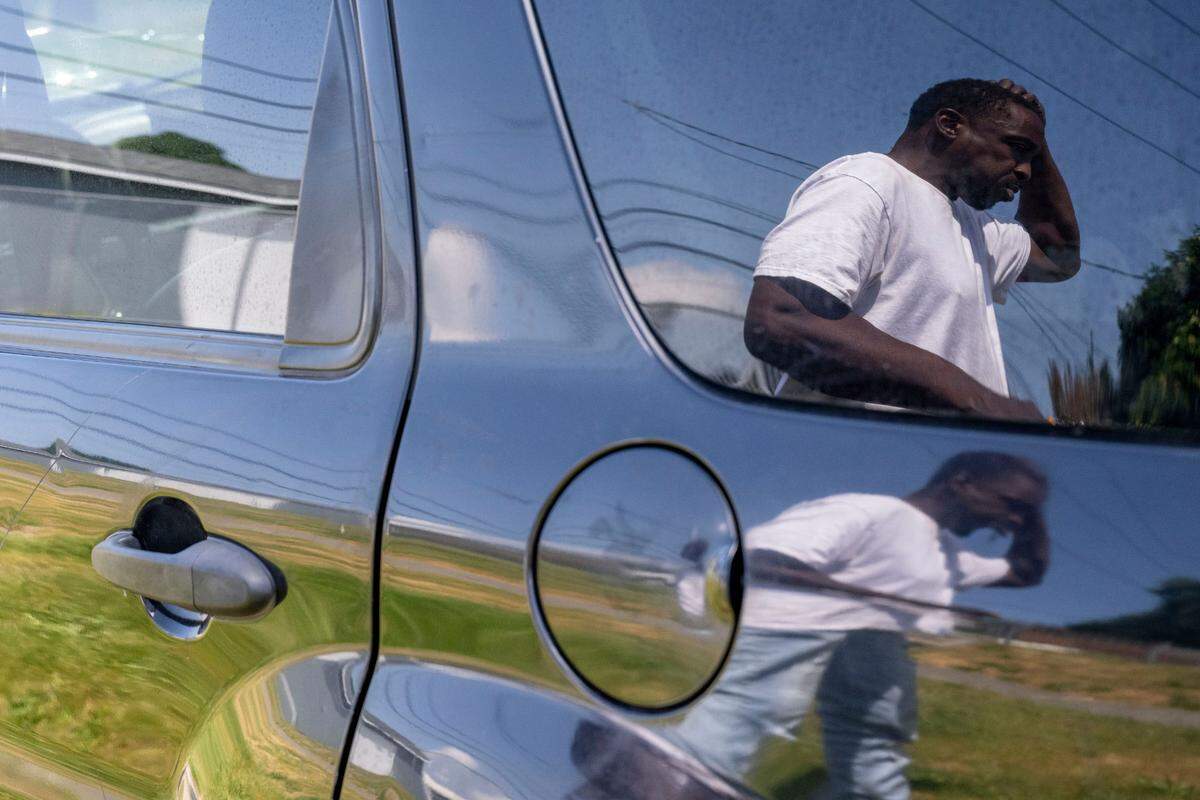 Ivory Kelly is seen in the reflection of an SUV that he was living in on Monday, May 29, 2023, in Tacoma, Wash.