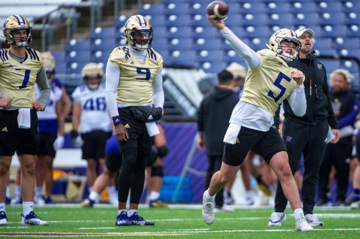Washington quarterback Dylan Morris attempts a pass as Michael Penix, Jr. (9) and Sam Huard (7) look on during drills at spring practice on Wednesday, March 30, 2022, at Husky Stadium in Seattle, Wash.