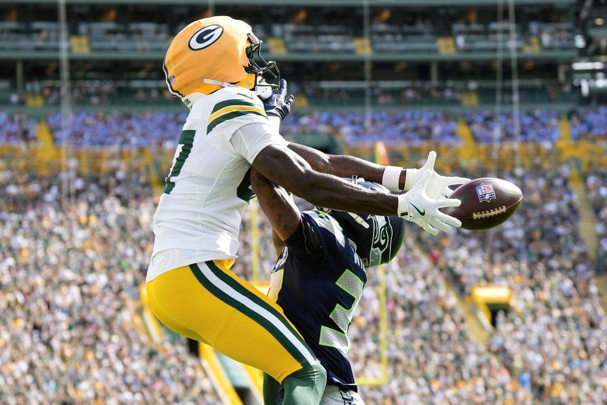 Seattle Seahawks cornerback Damarion Williams (37) commits a pass interference penalty as Green Bay Packers wide receiver Romeo Doubs (87) tries to catch a pass during the first quarter at Lambeau Field. Mandatory Credit: Jeff Hanisch-Imagn Images