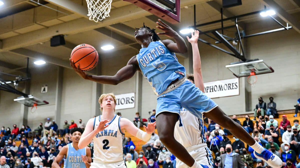 Curtis guard Zoom Diallo (5) attempts a reverse layup as Olympia guard Caden Roth (1) and forward Andreas Engholm (2) defend during the fourth quarter of a 4A South Puget Sound League tournament championship game on Saturday, Feb. 5, 2022, at Bethel High School in Spanaway, Wash.