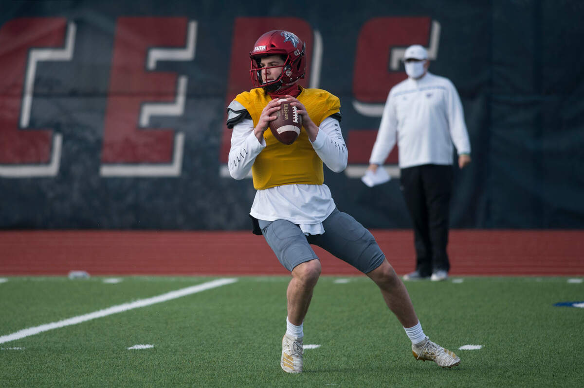 Kennedy Catholic High School quarterback Sam Huard drops back to pass as coach Sheldon Cross looks on during practice on Tuesday, March 23, 2021 at Kennedy Catholic High School in Burien, Wash.
