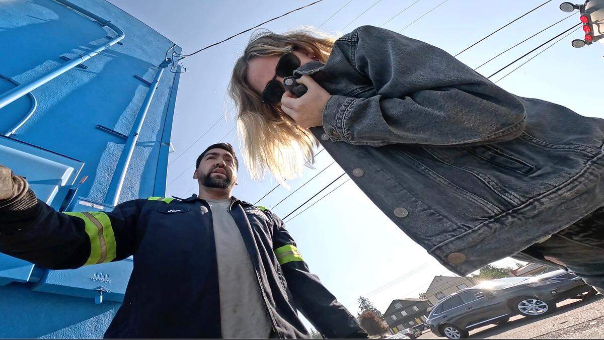 News Tribune reporter Kristine Sherred covers her nose near the exterior grease interceptors being cleaned by Juan Parada of West Coast Renewables in July. It definitely smells — sulfuric, mostly, like rotten eggs stuck in an airtight box for a little too long.