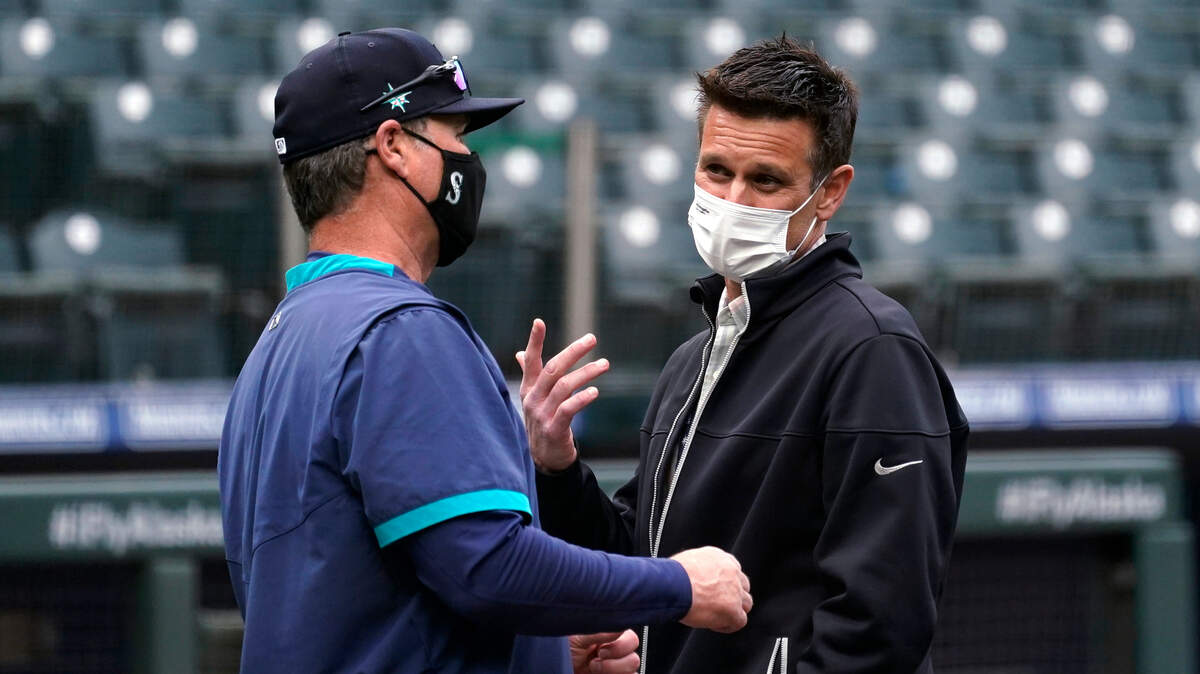 Seattle Mariners general manager Jerry Dipoto, right, talks with manager Scott Servais before the team’s baseball game against the San Francisco Giants on Thursday, April 1, 2021, in Seattle. (AP Photo/Elaine Thompson)