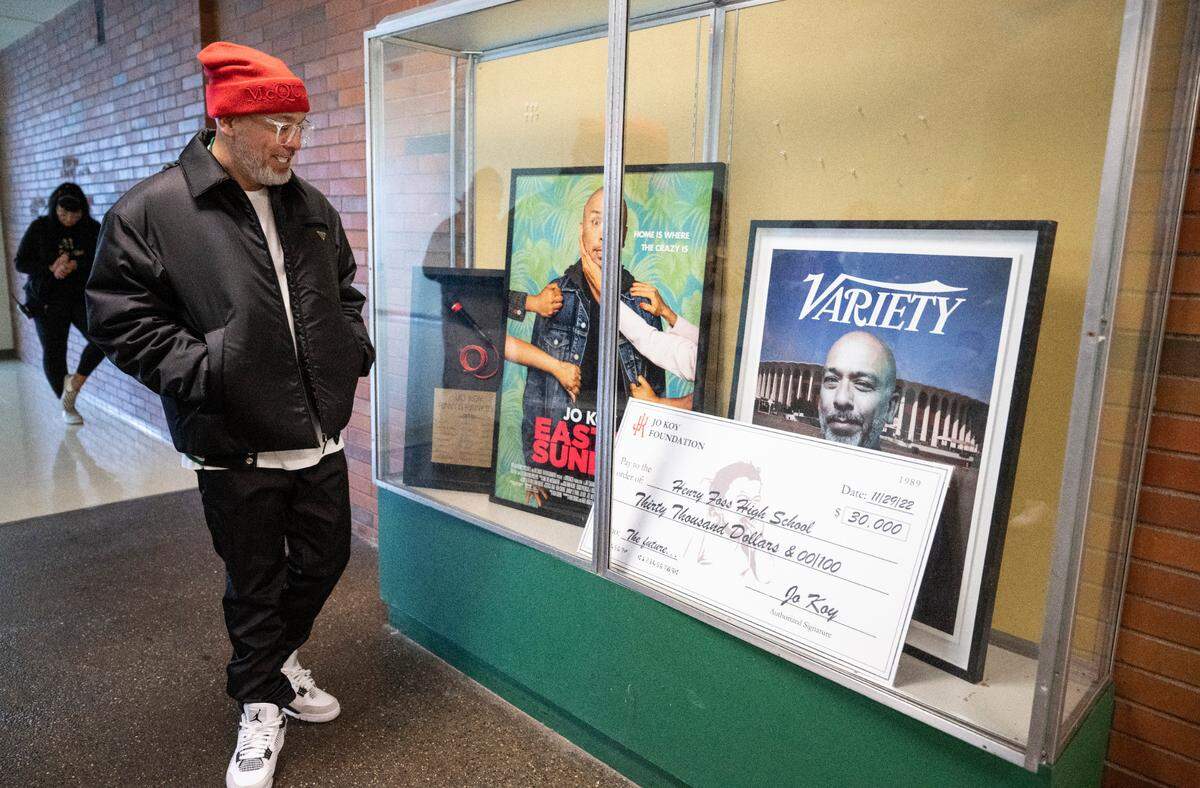 Comedian Jo Koy admires the framed poster from his movie “Easter Sunday”, a framed cover of Variety magazine and a microphone that he donated to his alma mater, Foss High School, along with a check for $30,000 to the Foss Scholarship Fund that will be dedicated to Foss students going into the arts.