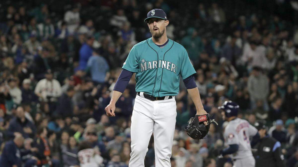 Seattle Mariners pitcher Shawn Armstrong stands on the mound as Houston Astros’ George Springer, right, nears third on the way to scoring on a grand slam by Jose Altuve during the sixth inning of a baseball game, Friday, April 12, 2019, in Seattle.