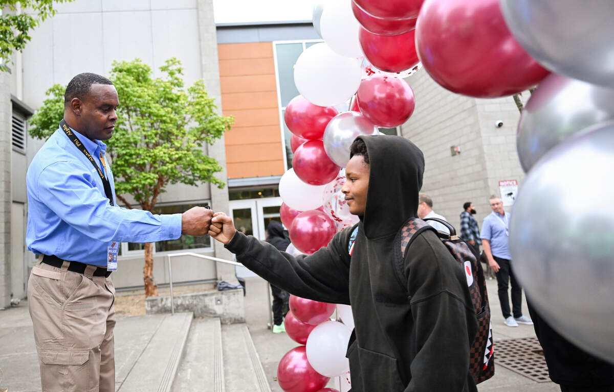 Tacoma Chief of Police Avery Moore fist-bumps Prince Hall, grade 8, and hands out PUSH For Dreams wristbands on the first day of school at Gray Middle School, on Monday, Sept. 9, 2024, in Tacoma.
