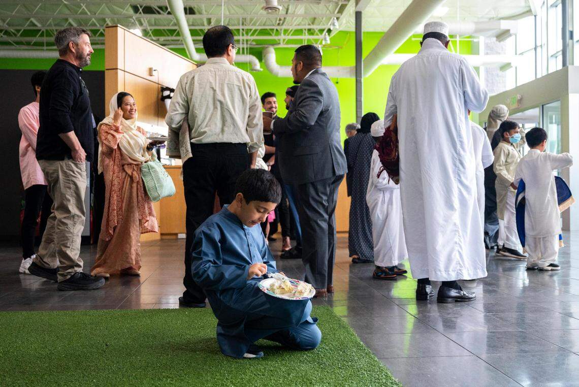 A boy kneels while eating cake after a prayer that was led by Imam Abdulhakim Mohammed for a celebration of the Islamic holiday, Eid al-Adha, at what will soon be the new Islamic Center on Montana Avenue in Tacoma, on Saturday, July 9, 2022.