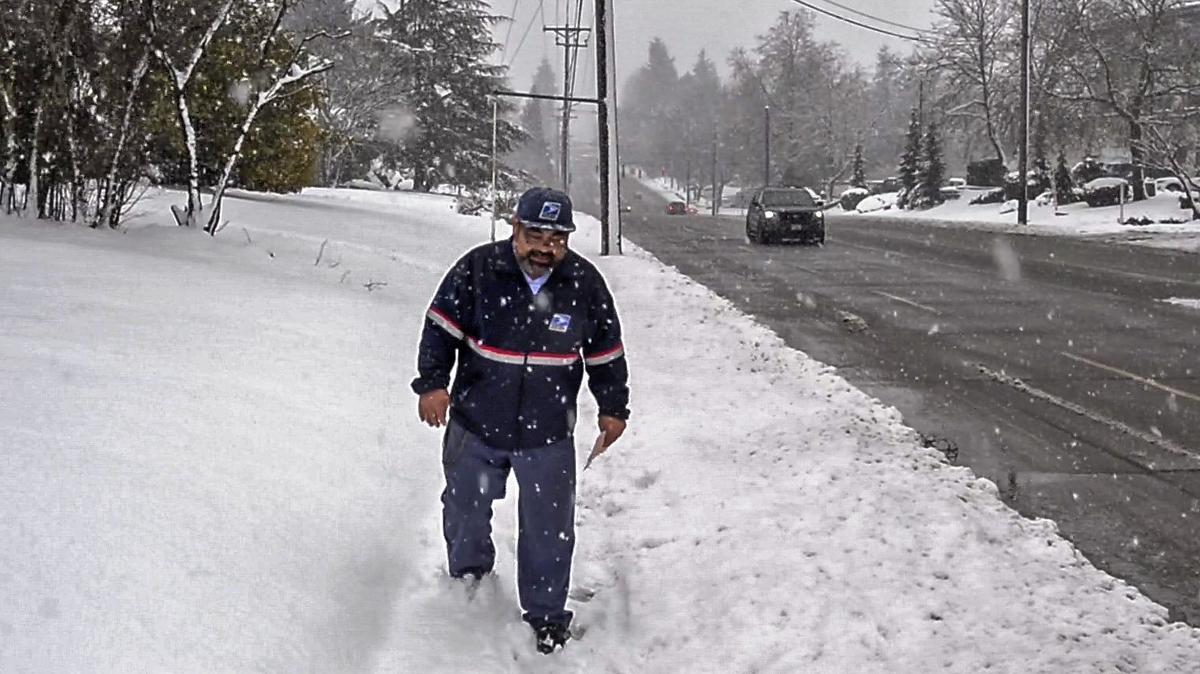 Postal carrier Tom Arndt delivers letters to homes along South 19th street in Tacoma, February 11, 2019. “I’m a skier, so I love this. That’s probably why you see me out here smiling,” he says. It’s the umpteenth day of snowfall in the Puget Sound area.