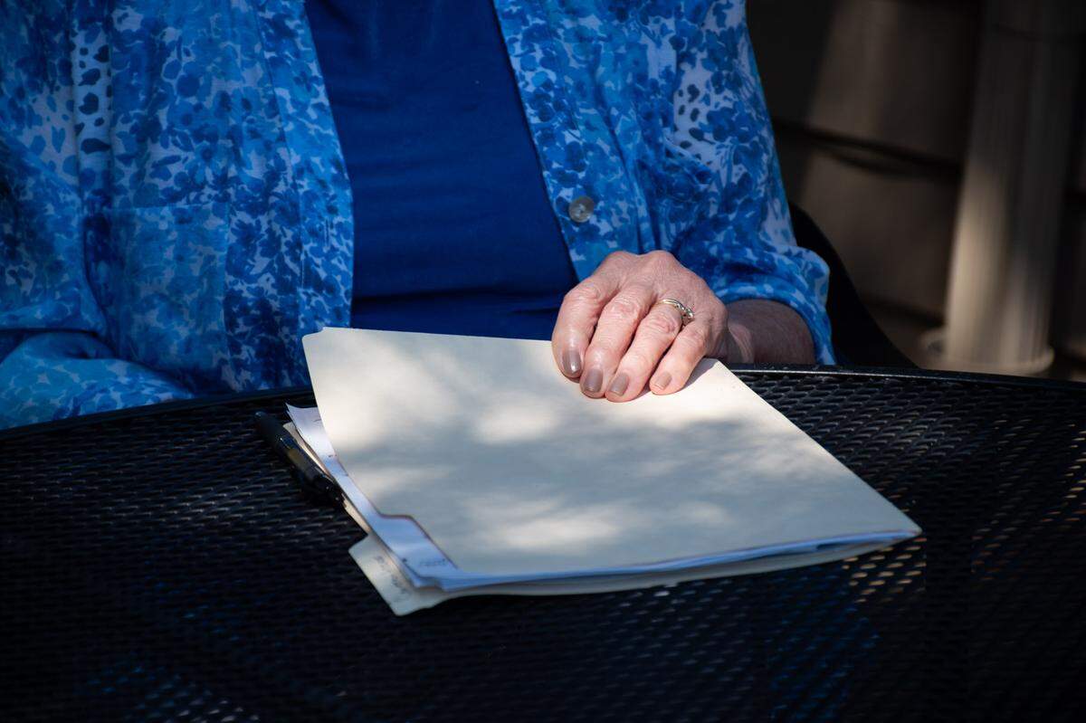 Barbara Rogers, of Gig Harbor, holds on to a folder on July 12, 2024, filled with email correspondence and notes from the times she’s tried to contact local and state officials about the entrance and exit of Haven of Rest, a local memorial park and funeral home off state Route 16 in the Gig Harbor area.