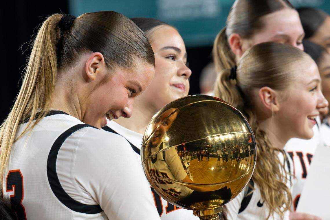 Davis guard Cheyenne Hull (13) smiles as she looks at her reflection in the Class 4A State Championship trophy after the Pirates beat Sumner, 61-45, at the Tacoma Dome on Saturday, March 8, 2025, in Tacoma.