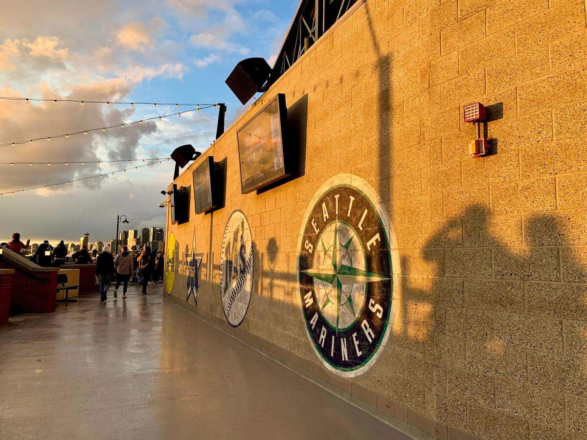 While the best food at T-Mobile Park in Seattle is assuredly on the main level, the upper deck provides the best views of downtown and the port. After an earlier light drizzle, plenty of fans took in the sunset from Boardwalk Alley on Saturday, April 16, 2022. The Mariners lost after winning their home opener against the Houston Astros.
