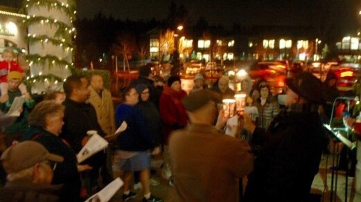 Coffee cups shielded the Menorah candles from a brisk wind and cast a warm glow as a small but well-bundled crowd greeted the first evening of Hanukkah in the plaza at Uptown Gig Harbor on Sunday night.