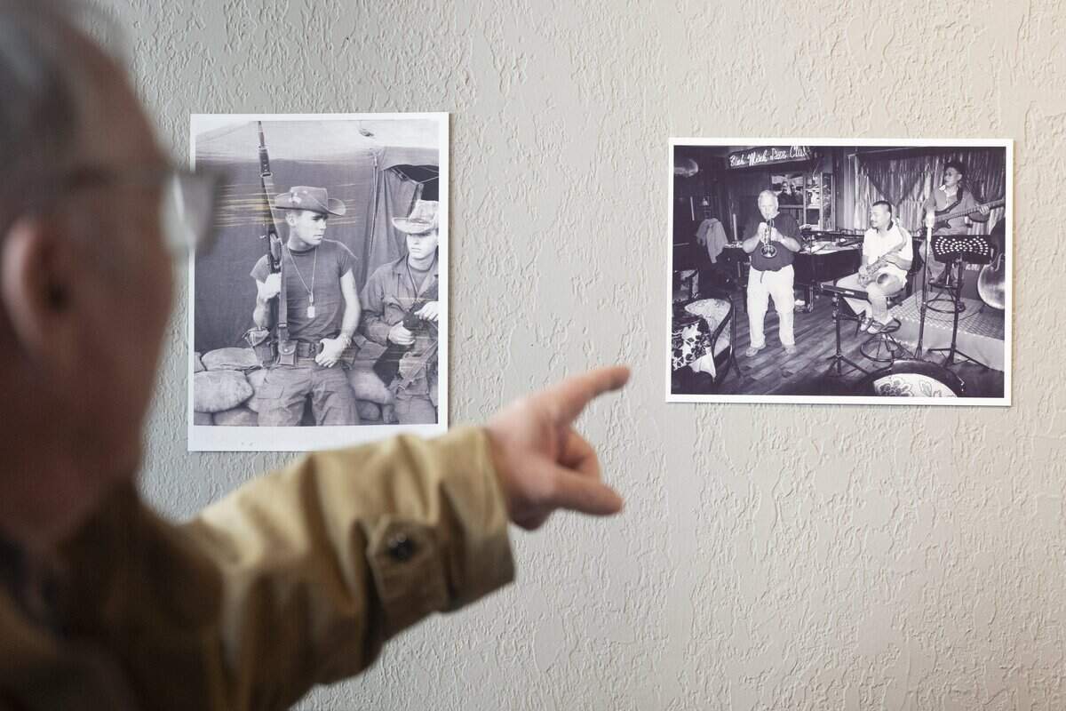 Photos of Richard Baker hang at the entrance of The Tobin Gallery on Tuesday, Jan. 20, 2026, in Tacoma, Wash. Baker, left, shares more about the photo of him before a patrol in the Army, and later playing in a band at a bar in Vietnam.